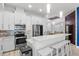 Modern white kitchen features a breakfast bar with stainless steel appliances and pendant lighting at 319 Compass Point Dr # 201, Bradenton, FL 34209