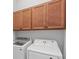 Bright laundry room featuring modern white appliances and matching wood storage cabinets above the units at 319 Compass Point Dr # 201, Bradenton, FL 34209