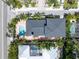 Aerial view of property displaying roof, pool, brick paved back patio, and tropical landscaping on a sunny day at 324 Siesta Dr, Sarasota, FL 34242