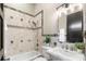 Bathroom boasts a tiled shower and backsplash, framed mirror, and ample sink space at 324 Siesta Dr, Sarasota, FL 34242