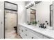 Bathroom featuring double sinks, a large mirror, and a glass enclosed shower at 324 Siesta Dr, Sarasota, FL 34242