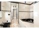 Bathroom featuring a marble backsplash, jacuzzi style tub, and a view into a hallway at 324 Siesta Dr, Sarasota, FL 34242