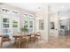 Modern dining room with light wood furniture, large windows, and seamless flow to kitchen at 324 Siesta Dr, Sarasota, FL 34242