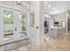 Inviting entryway featuring travertine floors, french doors, and a seamless transition to the modern kitchen at 324 Siesta Dr, Sarasota, FL 34242