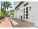 Brick-paved patio area featuring pristine white exterior of the home with well-manicured landscaping at 324 Siesta Dr, Sarasota, FL 34242