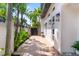 Charming exterior with mature landscaping, brick driveway, outdoor seating, and modern architectural details at 324 Siesta Dr, Sarasota, FL 34242