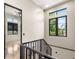 Bright hallway features sleek wrought iron railing, black trimmed windows and neutral paint at 324 Siesta Dr, Sarasota, FL 34242