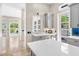 Wet bar area with beverage fridge and grey cabinets looks into a spacious living area with a pool view at 324 Siesta Dr, Sarasota, FL 34242
