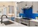 Modern kitchen features stainless steel appliances, gray cabinets, and blue backsplash, plus a view to other rooms at 324 Siesta Dr, Sarasota, FL 34242
