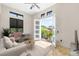 Charming staged living room features neutral paint, travertine floors and french doors to balcony at 324 Siesta Dr, Sarasota, FL 34242