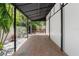 A brick-paved parking area with a black metal awning and an ornate metal gate leading to tropical landscaping at 324 Siesta Dr, Sarasota, FL 34242