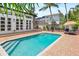 Stunning pool with brick pavers, steps for easy access, and beautiful views of the house and landscaping at 324 Siesta Dr, Sarasota, FL 34242