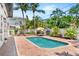 Backyard features a sparkling pool with brick pavers, tropical landscaping, and comfortable lounge seating at 324 Siesta Dr, Sarasota, FL 34242
