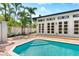 Inviting pool area with brick pavers, palm trees, and a stylish building with french doors at 324 Siesta Dr, Sarasota, FL 34242