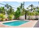 Tranquil pool area surrounded by lush tropical landscaping, brick pavers, and a privacy fence at 324 Siesta Dr, Sarasota, FL 34242