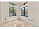 Bright empty room featuring modern black-trimmed windows and marble-like flooring at 324 Siesta Dr, Sarasota, FL 34242