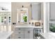 Stylish wet bar with white countertops, gray cabinets, and a beverage fridge for entertaining guests at 324 Siesta Dr, Sarasota, FL 34242