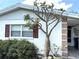 Charming home exterior with a decorative tree, red shutters, and well-maintained landscaping at 3321 Fuller St # 105, Sarasota, FL 34231