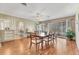 Open dining area with hardwood floors, modern lighting, and a glimpse into the kitchen and living area at 3402 Key Ave, Sarasota, FL 34239