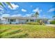 Lovely single-story home with mature trees and a well-maintained lawn under a bright, partly cloudy sky at 3402 Key Ave, Sarasota, FL 34239