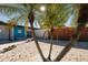 Charming front exterior with a colorful door, surrounded by beautiful palm trees and a stone-covered yard at 3402 Key Ave, Sarasota, FL 34239