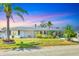 Charming single-story home featuring a well-manicured lawn and beautiful landscaping with mature palm trees at 3402 Key Ave, Sarasota, FL 34239