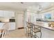 Bright, functional kitchen with white cabinets, countertop seating, and easy access to other areas at 3402 Key Ave, Sarasota, FL 34239