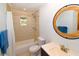 Bathroom showcases decorative tile, updated fixtures, built-in shower, and a round mirror above the updated sink at 3406 67Th Street E Ct, Bradenton, FL 34208