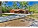 Charming single-Gathering home featuring a gravel driveway, boat carports, and lush, mature trees at 3406 67Th Street E Ct, Bradenton, FL 34208
