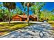 Charming single-Gathering home featuring a gravel driveway, boat carports, and lush, mature trees at 3406 67Th Street E Ct, Bradenton, FL 34208