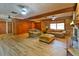 Cozy living room with a brick fireplace, wood look floors, wood paneling, comfortable furniture and natural light at 3406 67Th Street E Ct, Bradenton, FL 34208