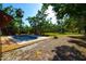 An inground pool is complemented by a lush green yard featuring mature trees and an outdoor kitchen, perfect for outdoor gatherings at 3406 67Th Street E Ct, Bradenton, FL 34208