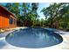 This outdoor space features a refreshing pool and an outdoor cooking space with lush greenery and mature trees, offering a private retreat at 3406 67Th Street E Ct, Bradenton, FL 34208