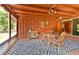 Enclosed porch showcases wood accents and a ceiling fan over the dining table with seating for four at 3406 67Th Street E Ct, Bradenton, FL 34208