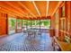 Enclosed porch with wood ceiling and accents features plenty of natural light and a table for dining at 3406 67Th Street E Ct, Bradenton, FL 34208