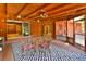 Enclosed porch features wood-clad ceiling and walls, a dining table, and access to the backyard at 3406 67Th Street E Ct, Bradenton, FL 34208