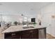 Open kitchen with island sink and stainless dishwasher, flowing into the adjacent dining and living areas at 3478 74Th Avenue E Cir, Sarasota, FL 34243