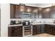 Gourmet kitchen showcases stainless steel appliances, granite countertops, and rich dark wood cabinets at 3478 74Th Avenue E Cir, Sarasota, FL 34243