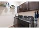 Laundry room with modern stainless steel washer and dryer, and overhead storage at 3478 74Th Avenue E Cir, Sarasota, FL 34243