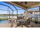 Relaxing screened-in patio with a dining set, lounge chairs, and a beautiful pool view at 3478 74Th Avenue E Cir, Sarasota, FL 34243