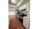 Kitchen featuring stainless steel appliances, white cabinets, and terra cotta floor tiles at 3705 Chinaberry Rd, Bradenton, FL 34208