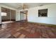 Open floor plan room with adjacent rooms, ceiling fans, a pass-through window, and red tile floors at 3705 Chinaberry Rd, Bradenton, FL 34208