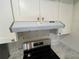 Modern black gas stove with stainless steel hood and white cabinets against marble countertops at 3705 Chinaberry Rd, Bradenton, FL 34208