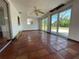 Spacious sunroom area with terra cotta floors, ceiling fan, large windows and sliding glass doors at 3705 Chinaberry Rd, Bradenton, FL 34208