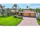 Beautiful waterfront home with lush landscaping, a paver driveway, and a spacious three-car garage at 3716 Coconut Ter, Bradenton, FL 34210
