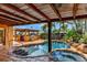 An inviting backyard featuring a covered patio, custom pool and spa, and tropical landscaping, ideal for relaxation at 3716 Coconut Ter, Bradenton, FL 34210