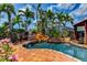 Backyard with a lagoon-style pool, waterfall feature, and lush tropical landscaping at 3716 Coconut Ter, Bradenton, FL 34210