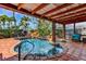 A backyard pool featuring a stone waterfall, tropical plants, and a built-in spa, perfect for outdoor relaxation at 3716 Coconut Ter, Bradenton, FL 34210