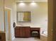 Bathroom featuring a wooden vanity with a framed mirror and a soaking tub at 406 Petrel Trl, Bradenton, FL 34212