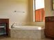 A well-lit bathroom featuring a tile-trimmed soaking tub beneath a bright window at 406 Petrel Trl, Bradenton, FL 34212